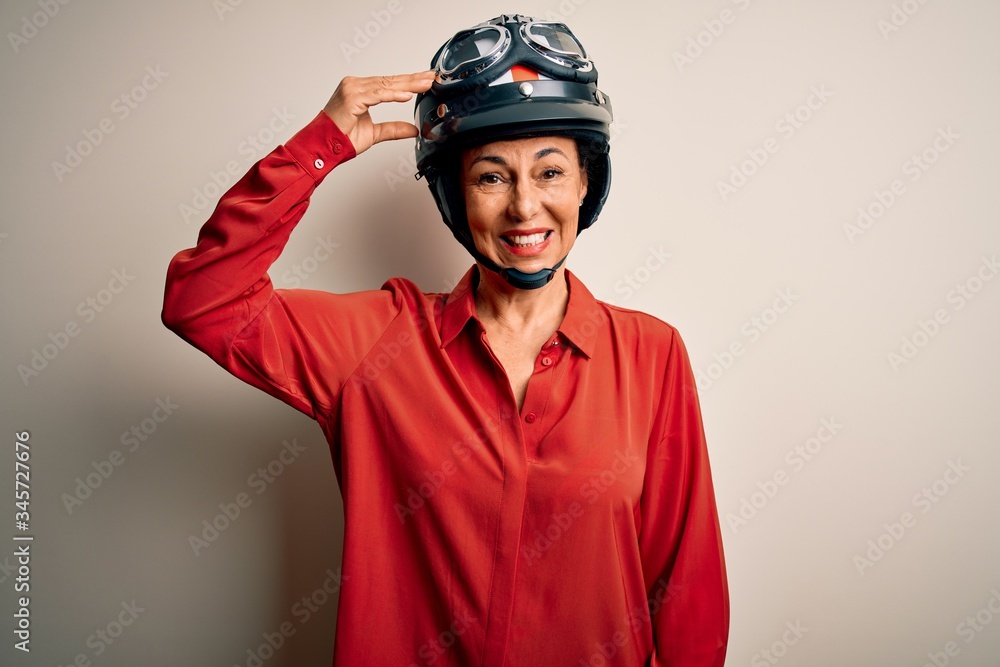 Middle age motorcyclist woman wearing motorcycle helmet over isolated white background confuse and wonder about question. Uncertain with doubt, thinking with hand on head. Pensive concept. Middle age motorcyclist woman wearing motorcycle helmet over isolated white background confuse and wonder about question. Uncertain with doubt, thinking with hand on head. Pensive concept.