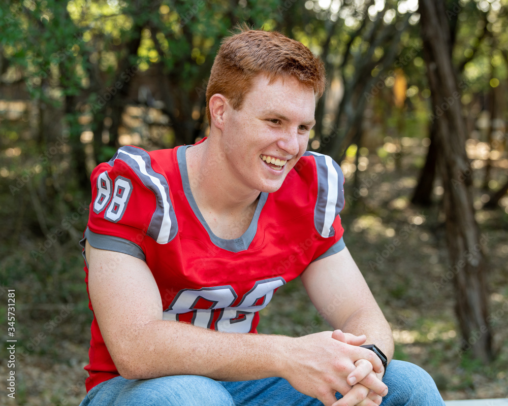 Fototapeta premium Young, attractive boy with red hair taking graduation pictures
