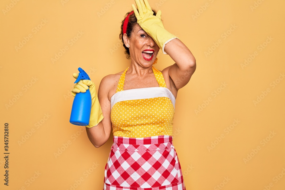 Middle age senior housewife pin up woman wearing 50s style retro dress cleaning using spray stressed with hand on head, shocked with shame and surprise face, angry and frustrated. Fear and upset Middle age senior housewife pin up woman wearing 50s style retro dress cleaning using spray stressed with hand on head, shocked with shame and surprise face, angry and frustrated. Fear and upset