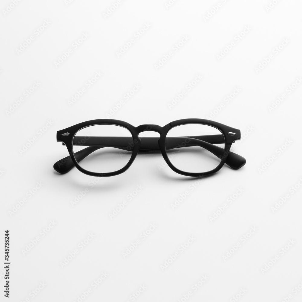 Straight closeup view of modern black eyeglasses on flat white background isolated Straight closeup view of modern black eyeglasses on flat white background isolated