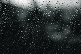 Raindrops of white water falling down on glass. Perfect for digital composing. Gloom black background.
