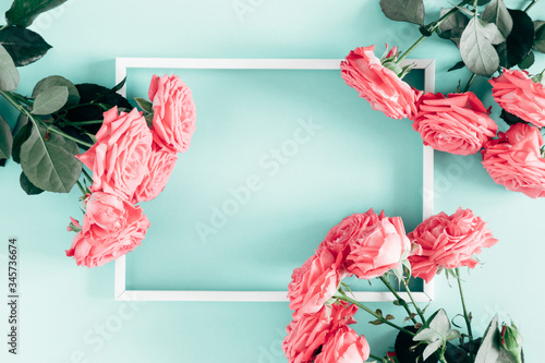 Fototapeta Naklejka Na Ścianę i Meble -  Beautiful flowers composition. Blank frame for text, pink rose flowers on pastel mint background. Valentines Day, Easter, Birthday, Happy Women's Day, Mother's day. Flat lay, top view, copy space
