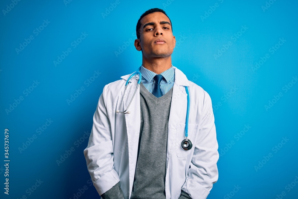 Handsome african american doctor man wearing coat and stethoscope over blue background looking sleepy and tired, exhausted for fatigue and hangover, lazy eyes in the morning. Handsome african american doctor man wearing coat and stethoscope over blue background looking sleepy and tired, exhausted for fatigue and hangover, lazy eyes in the morning.