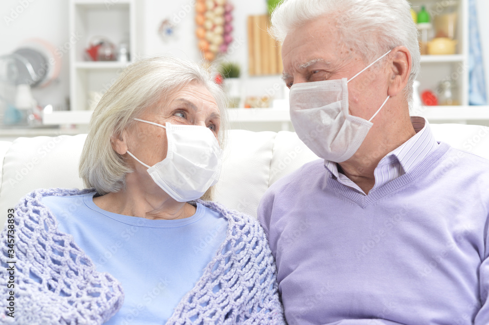 Portrait of sick elderly woman and man with facial masks