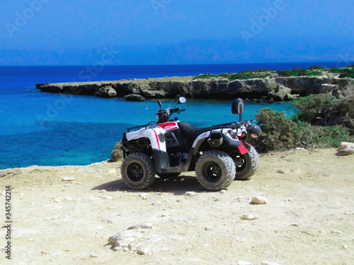 Quad bike on white sand near the blue sea and sky. Summer sports holidays. Akamas Nature Reserve, Cyprus.