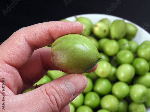 sour nectarine fruit in a person's hand,close-up raw nectarine and sour plum