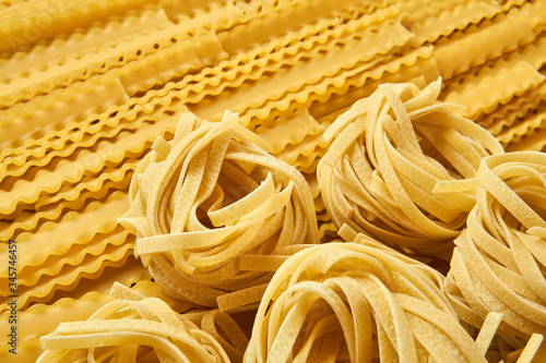 background of dried pasta, tagliatelle and mafaldini photo