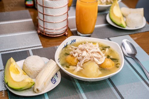 Fototapeta Naklejka Na Ścianę i Meble -  Ajiaco Santafereño, plato tipico colombiano, comida típica del interior de Colombia acompañado de jugo de mango 