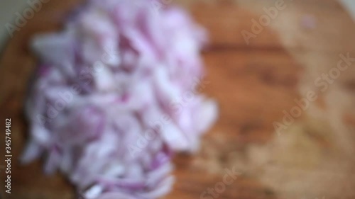 blurred view of cut onion on wooden chopping board with copy space
