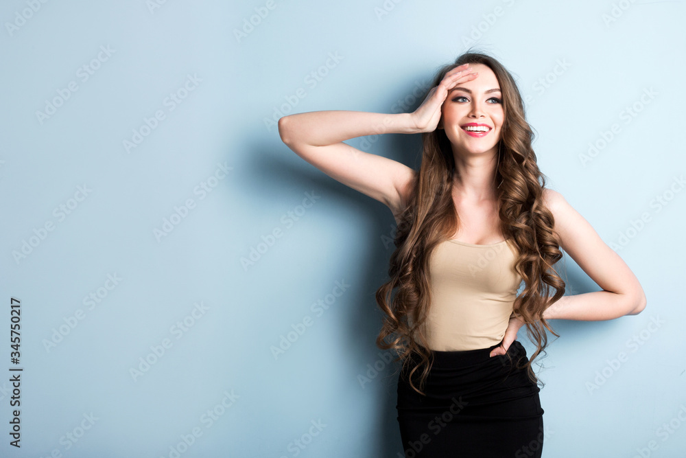 Attractive excited young woman wearing casual clothing standing isolated over blue background. Attractive excited young woman wearing casual clothing standing isolated over blue background.