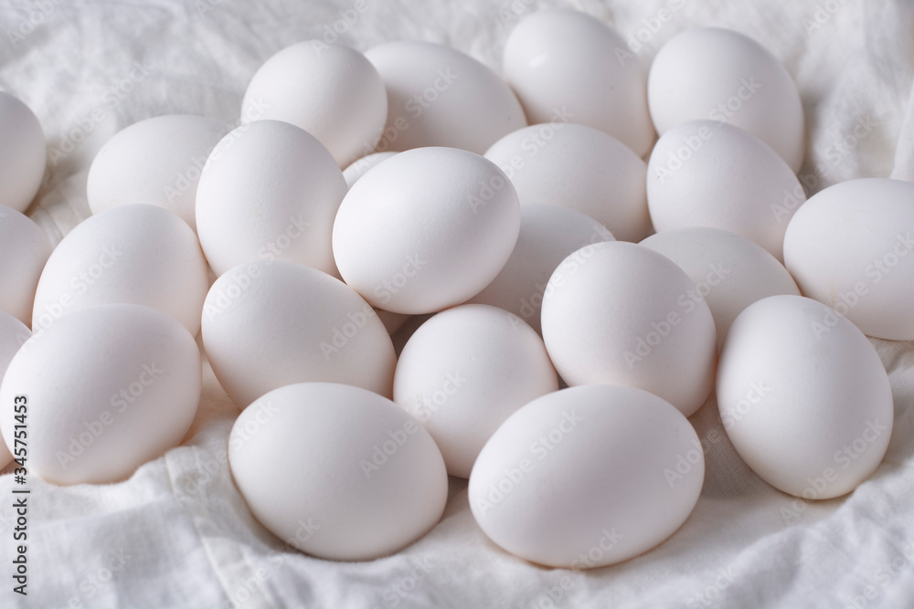 White chicken eggs on a white linen cloth. White chicken eggs on a white linen cloth.