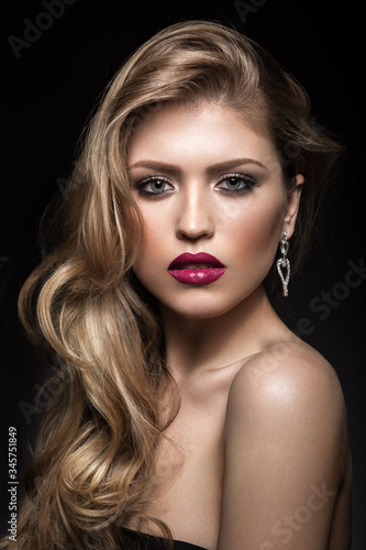 Beautiful girl with red lips and classic makeup and curls. Beauty face