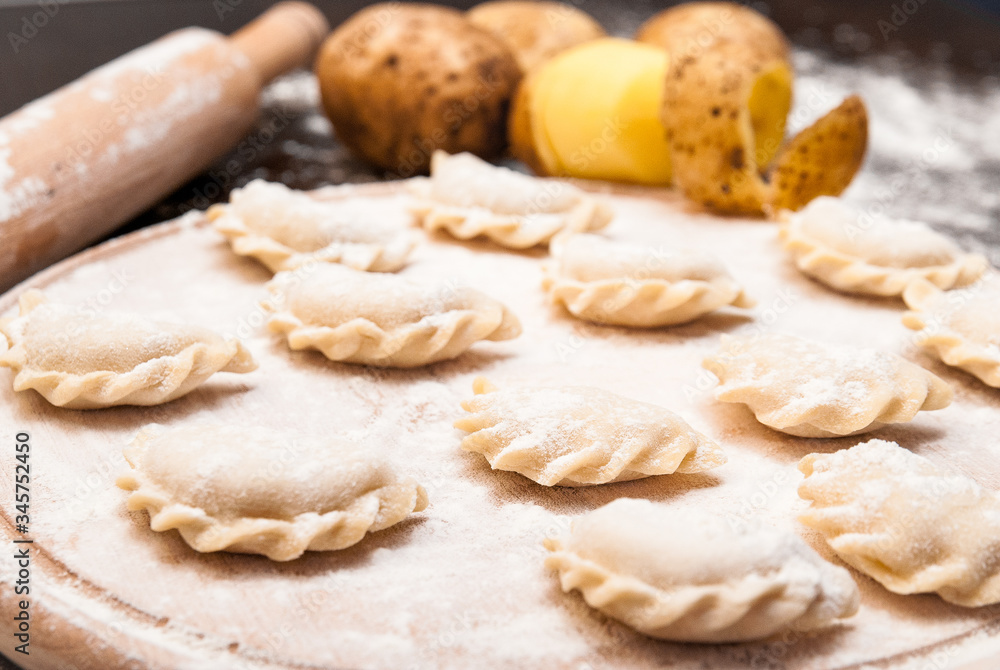 Homemade raw dumplings with filling on a wooden board Homemade raw dumplings with filling on a wooden board