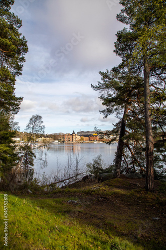  Sweden. View across the lake to the Gustavsberg promenade under a blue spring sky