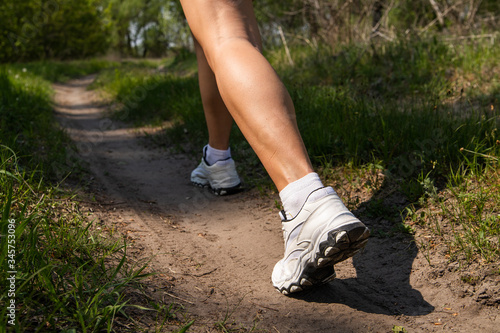 Athletic woman on running track getting ready to start run, back view. athletic legs of a girl