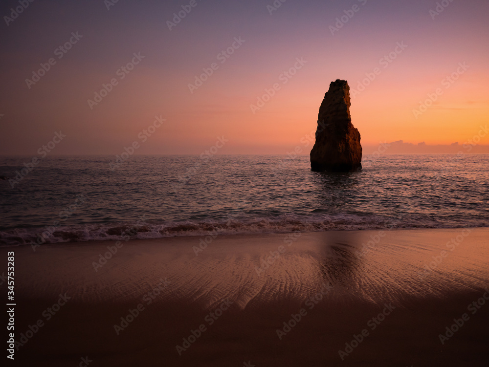 Sunset in front of the big lonely rock. Algarve, Portugal.