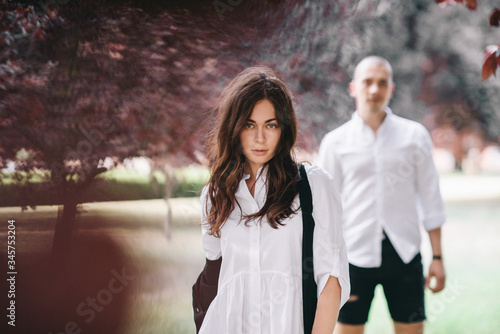 A porttret of a young caucasian stylish couple walking on beautiful park photo