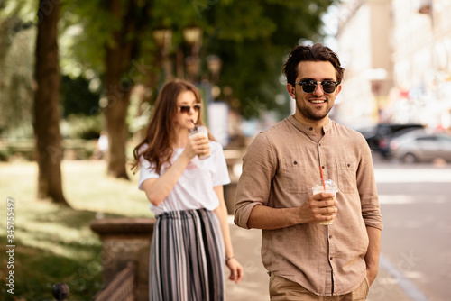 young beautiful couple have a fun and walking on city streets and drinking coffee