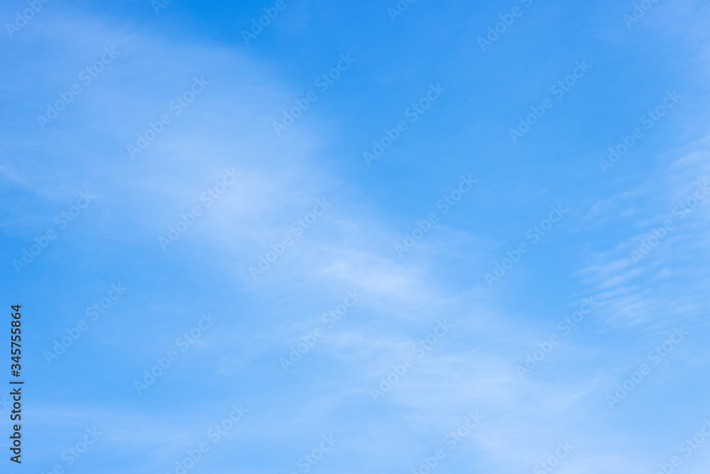 Obraz premium blue clear spring sky covered with small white clouds. the concept of a peaceful sky over your head