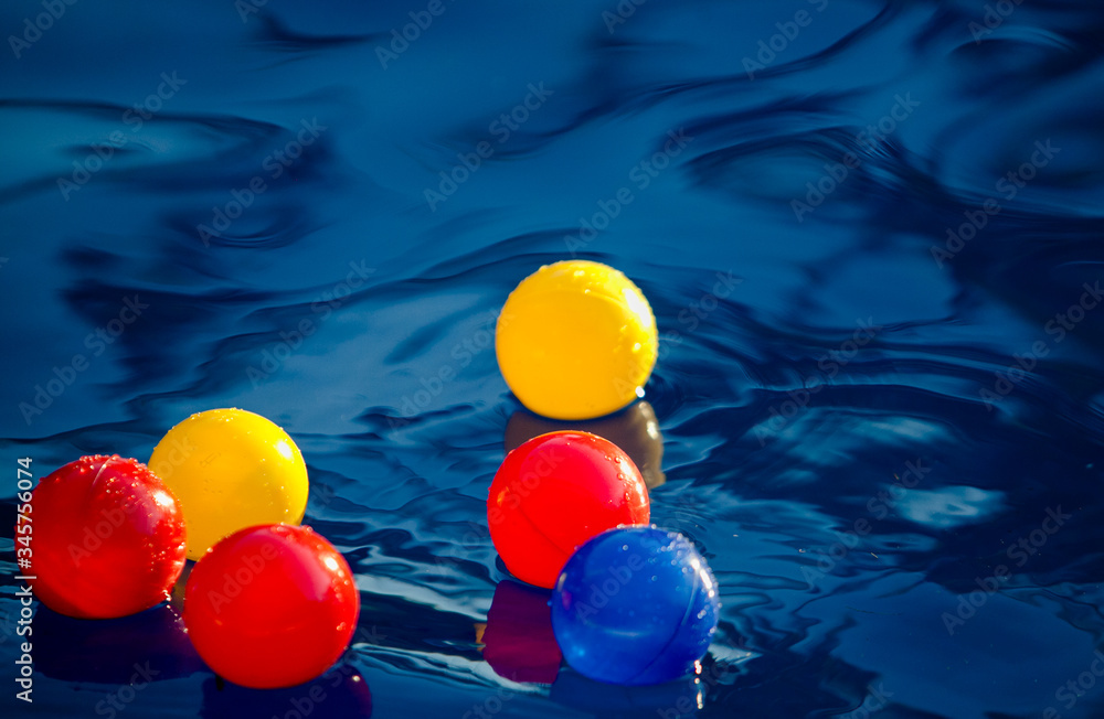 Colorful balls in the swimming pool at night