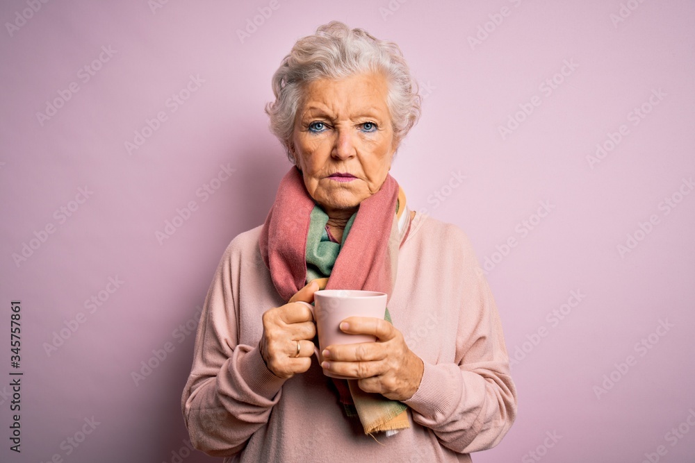 Senior beautiful grey-haired woman drinking mug of coffee over isolated pink background with a confident expression on smart face thinking serious Senior beautiful grey-haired woman drinking mug of coffee over isolated pink background with a confident expression on smart face thinking serious