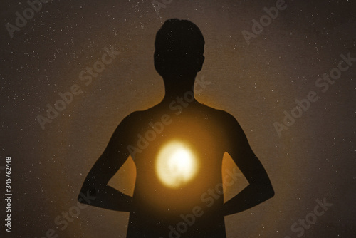 Female silhouette radiating light from within a spiritual heart opening.