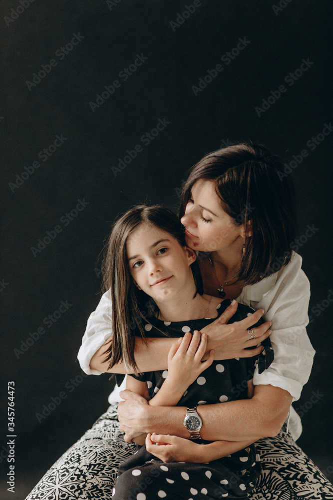 Loving mother and daughter gently hug each other, they smile and enjoy communication. A photo with a blurred background. Loving mother and daughter gently hug each other, they smile and enjoy communication. A photo with a blurred background.