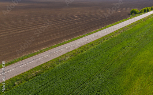 aerial view, dirt road divides green and brown field