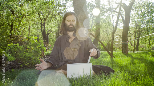 A qigong master conducts meditation using a gong and Crystal bowl, Crystal Tibetian singing bowl, a master meditates receives energy for the body photo