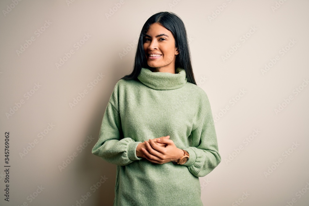 Young beautiful hispanic woman wearing green winter sweater over isolated background with hands together and crossed fingers smiling relaxed and cheerful. Success and optimistic Young beautiful hispanic woman wearing green winter sweater over isolated background with hands together and crossed fingers smiling relaxed and cheerful. Success and optimistic