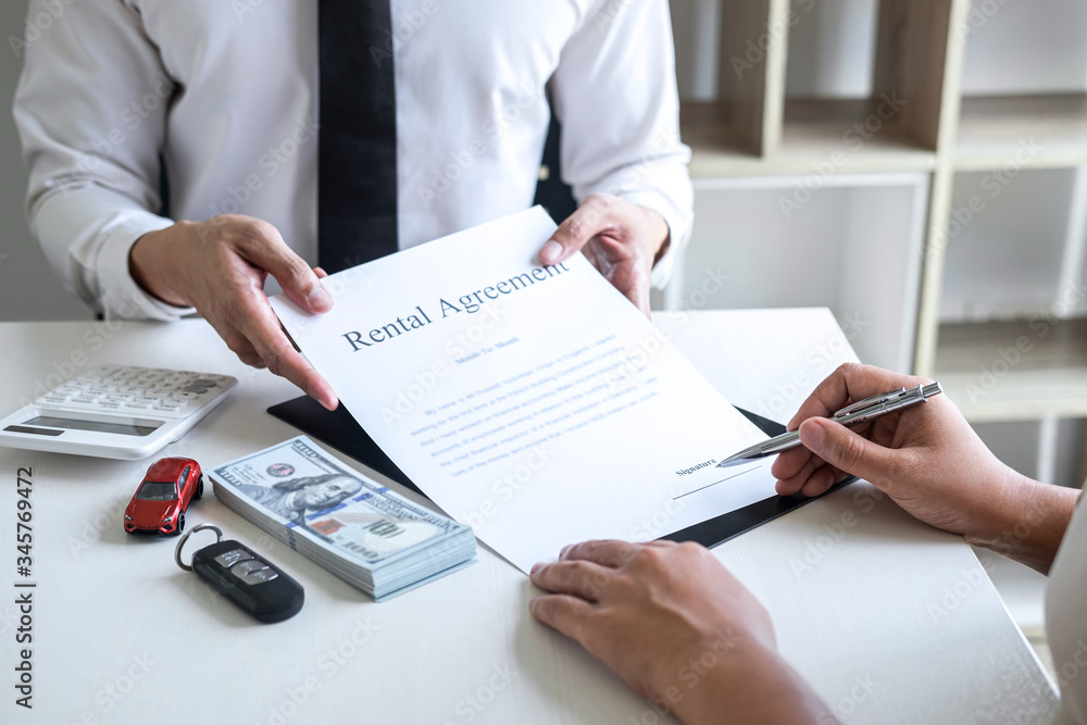 Realtor agent manager holding rental contract form to woman client for decide signing to agreement, renting considering vehicle car insurance Realtor agent manager holding rental contract form to woman client for decide signing to agreement, renting considering vehicle car insurance