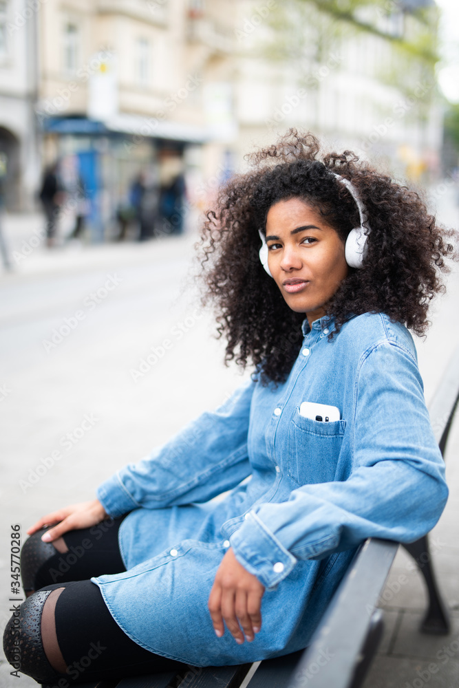 Lässige junge Frau mit Afro und Kopfhörern Lässige junge Frau mit Afro und Kopfhörern