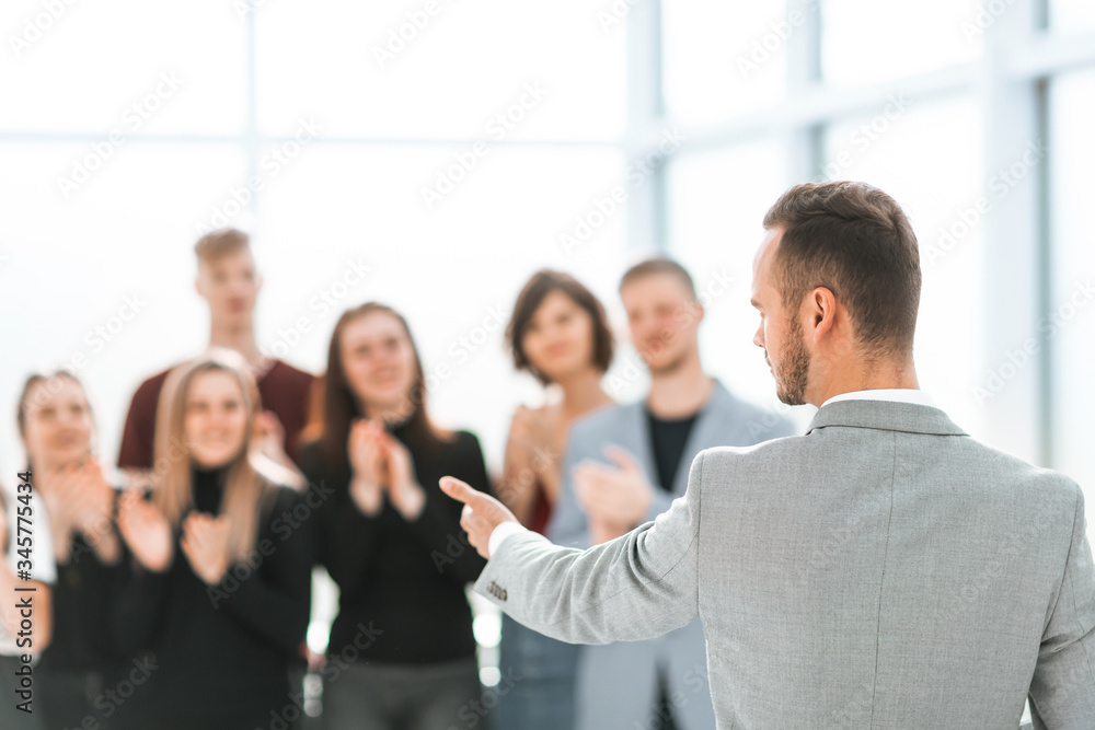 blurred image of a group of young people applauding their speak blurred image of a group of young people applauding their speak