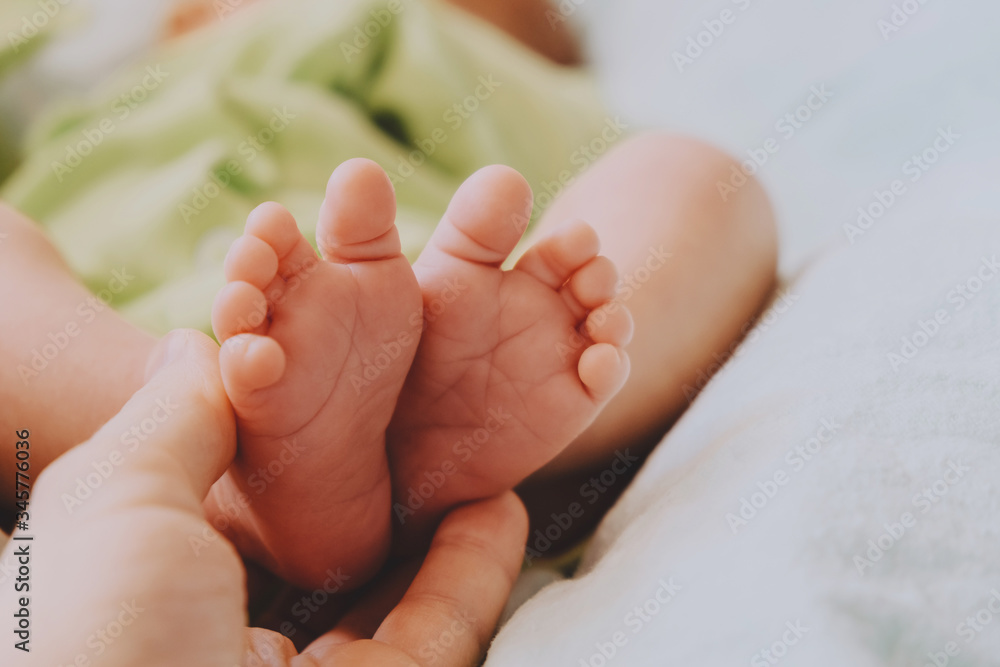 Maternity concept. Mom's hand touching cute little newborn baby feet. Maternity concept. Mom's hand touching cute little newborn baby feet.