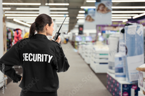 Photo Security guard using portable radio transmitter in shopping mall, space for text