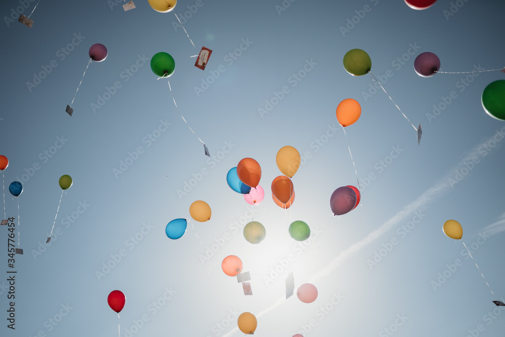 photo of colorful helium balloons flying in the sky photo of colorful helium balloons flying in the sky