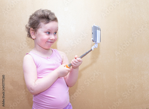 A girl  a preschooler  makes a selfie on a smartphone. Copy space