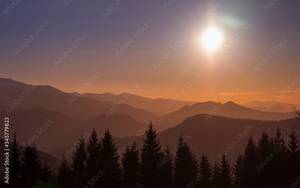 Silhouettes of mountains and trees in a sunrise with scenic view