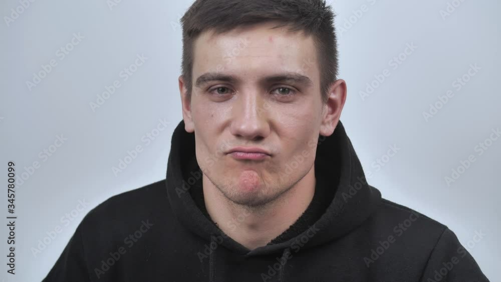 Attractive guy smiles sincerely, looking at the camera, isolated on white blurred background. Close up. 4k Attractive guy smiles sincerely, looking at the camera, isolated on white blurred background. Close up. 4k
