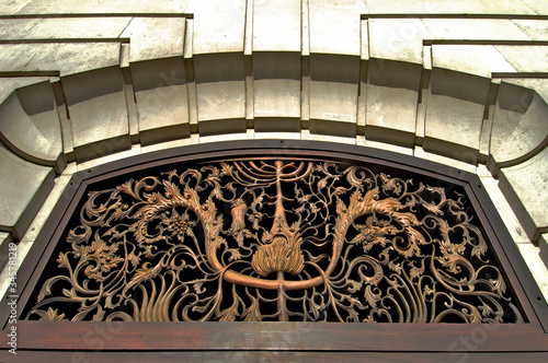 Closeup of detailed filigree tracery metal work in transom above door, London 