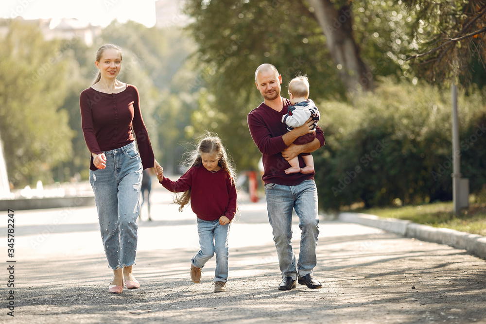 Family in a autumn park. Woman in a red sweater. Cute childrens with parents Family in a autumn park. Woman in a red sweater. Cute childrens with parents
