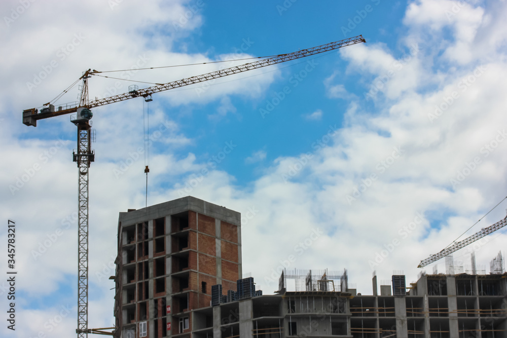 Construction of an apartment building in the city: a construction crane against the sky