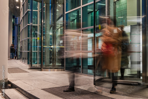  The flow of people passing through the rotating door of the modern office building ,