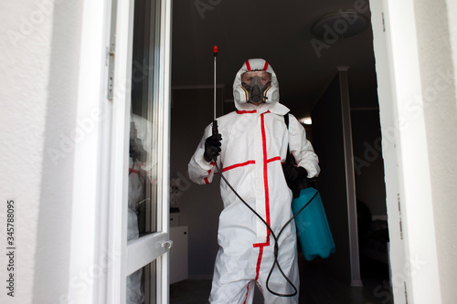 coronavirus disinfection inside the house. The disinfector in the Hazmat cleans the apartment from viruses and infections