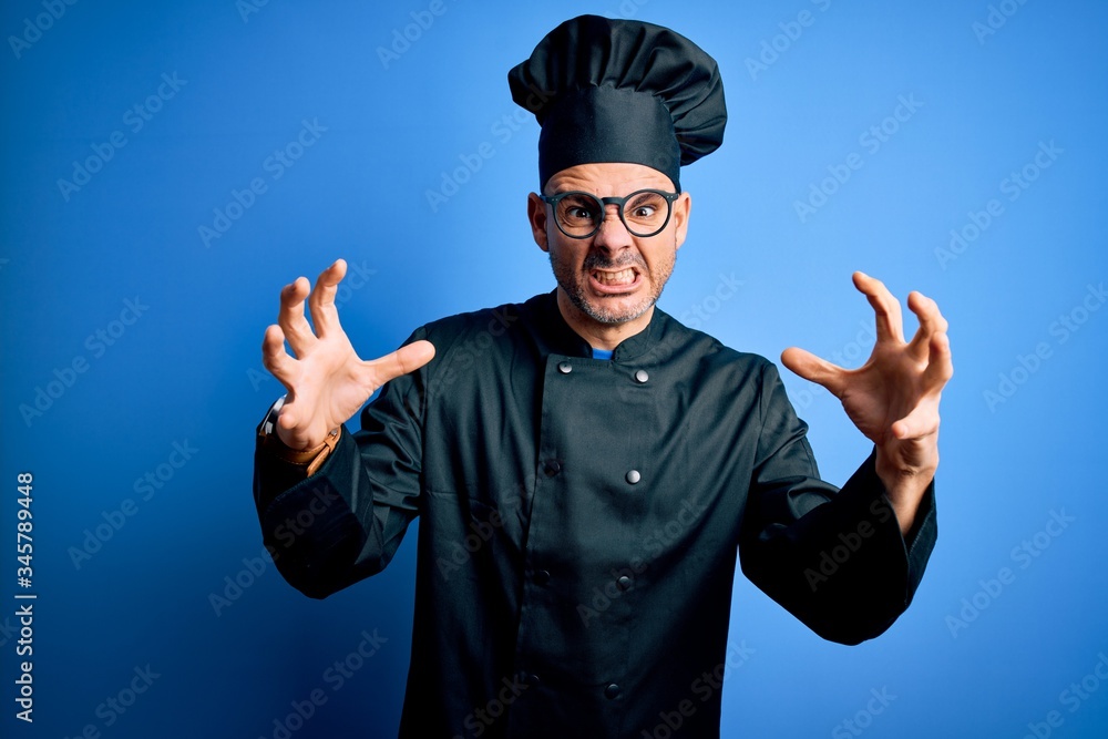Young handsome chef man wearing cooker uniform and hat over isolated blue background Shouting frustrated with rage, hands trying to strangle, yelling mad Young handsome chef man wearing cooker uniform and hat over isolated blue background Shouting frustrated with rage, hands trying to strangle, yelling mad