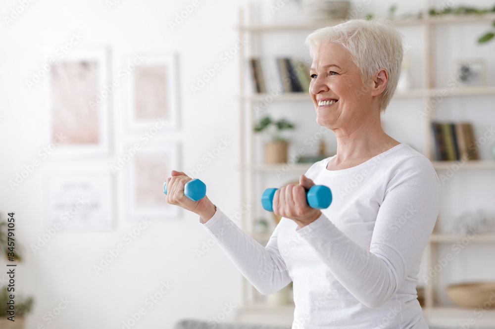 Gym At Home. Aged Woman Training With Dumbbells In Living Room Gym At Home. Aged Woman Training With Dumbbells In Living Room