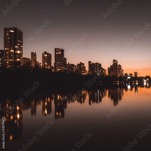 night in the city reflected in the lake with orange sunset