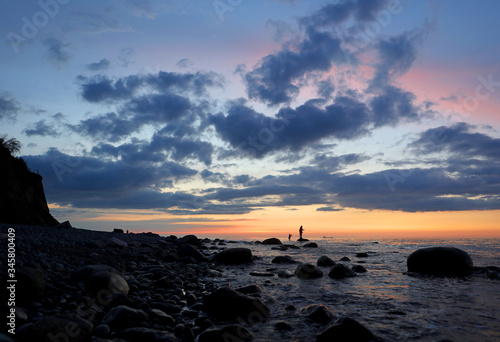 Einsame Steilküste in der Nähe von Rostock an der Ostsee mit Fähre. Typisches deutsches Reiseziel. Fischer in der Abendstimmung