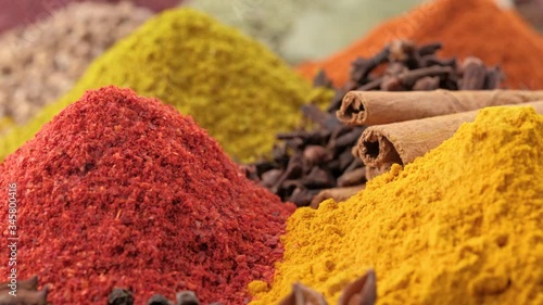 Assortment of fragrant Indian spices in the market, camera moves between heaps of seasonings and herbs. Cooking ingredients, flavor.