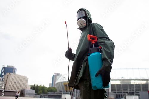 Coronavirus pandemic. disinfection service worker in a protective suit cleans the streets of the city from virus and infection with chemicals